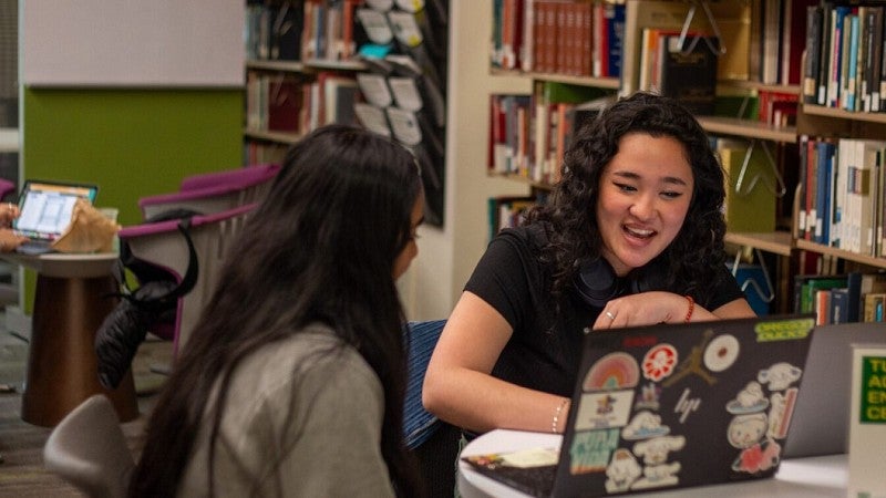 two students of color using laptops