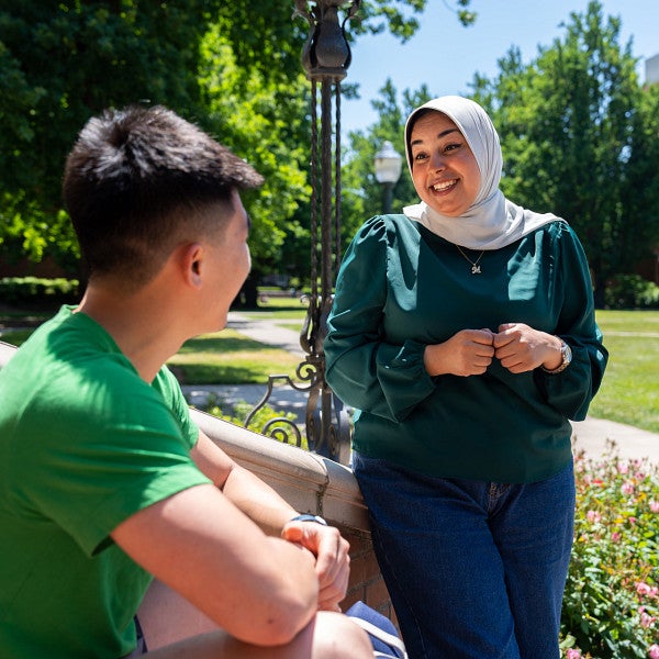 students talking on campus with PLC building in the background